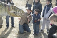 A young chld is thrilled to meet a dinosour at yesterdays event 