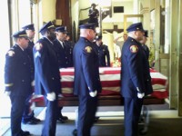 Fellow Police Officers carry JCPD Officer Melivn Santiago's casket into St. Aloysius Church 